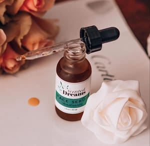 Face serum bottle with dropper, surrounded by roses for skincare.